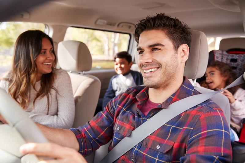 A happy family takes a car ride after securing a good deal on an auto loan.